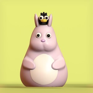 May include: A pink plush toy shaped like a rabbit with a small black bird perched on its head. The rabbit has large eyes and a white belly.