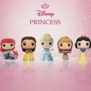 Op de afbeelding: Vijf Funko Pop! figuren van Disney-prinsessen: Ariel, Belle, Assepoester, Aurora en Sneeuwwitje. Elke figuur heeft een kenmerkende outfit, Ariel op een voetstuk met bloemen en een krab. Het Disney Princess-logo staat bovenaan.