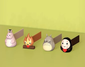 May include: Four colorful character figurines with a small black bird on top of the first figurine. The figurines are attached to a small rectangular piece of paper. The figurines are on a light green background.