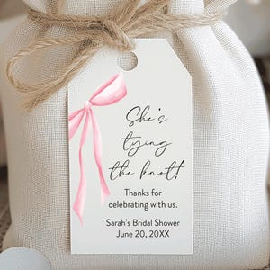 She's tying the knot! Favor tag with a pink bow printed on the left side.