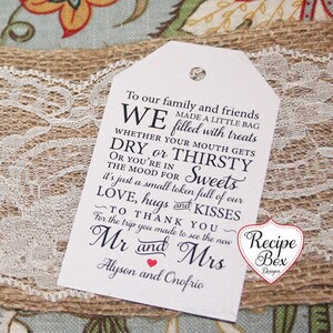 May include: A white gift tag with black text that reads "To our family and friends WE made a little bag filled with treats WHETHER YOUR MOUTH GETS DRY or THIRSTY OR YOU'RE IN THE MOOD FOR Sweets it's just a small token full of our LOVE, hugs KISSES TO THANK YOU for the trip you made to see the new Mr and Mrs Alyson and Onofrio". The tag is sitting on a burlap surface with white lace.