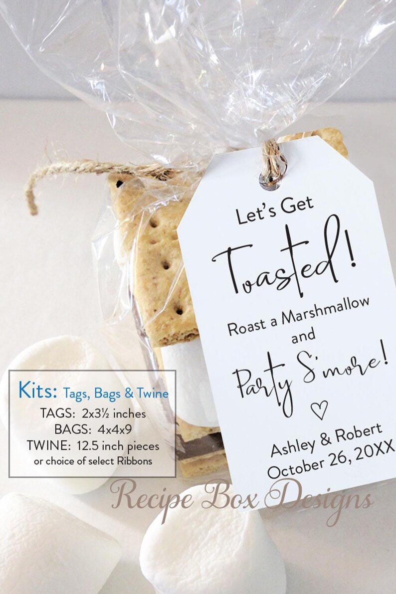 May include: A clear cellophane bag tied with twine, containing a s'mores kit. A white tag reads "Let's Get Toasted!" with event details. The kit includes graham crackers, marshmallows, and chocolate.