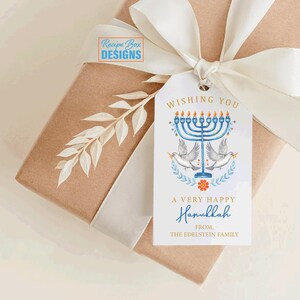 May include: A gift wrapped in brown paper with a white ribbon and a Hanukkah gift tag. The tag features a blue menorah, doves, and the text "Wishing You A Very Happy Hanukkah".
