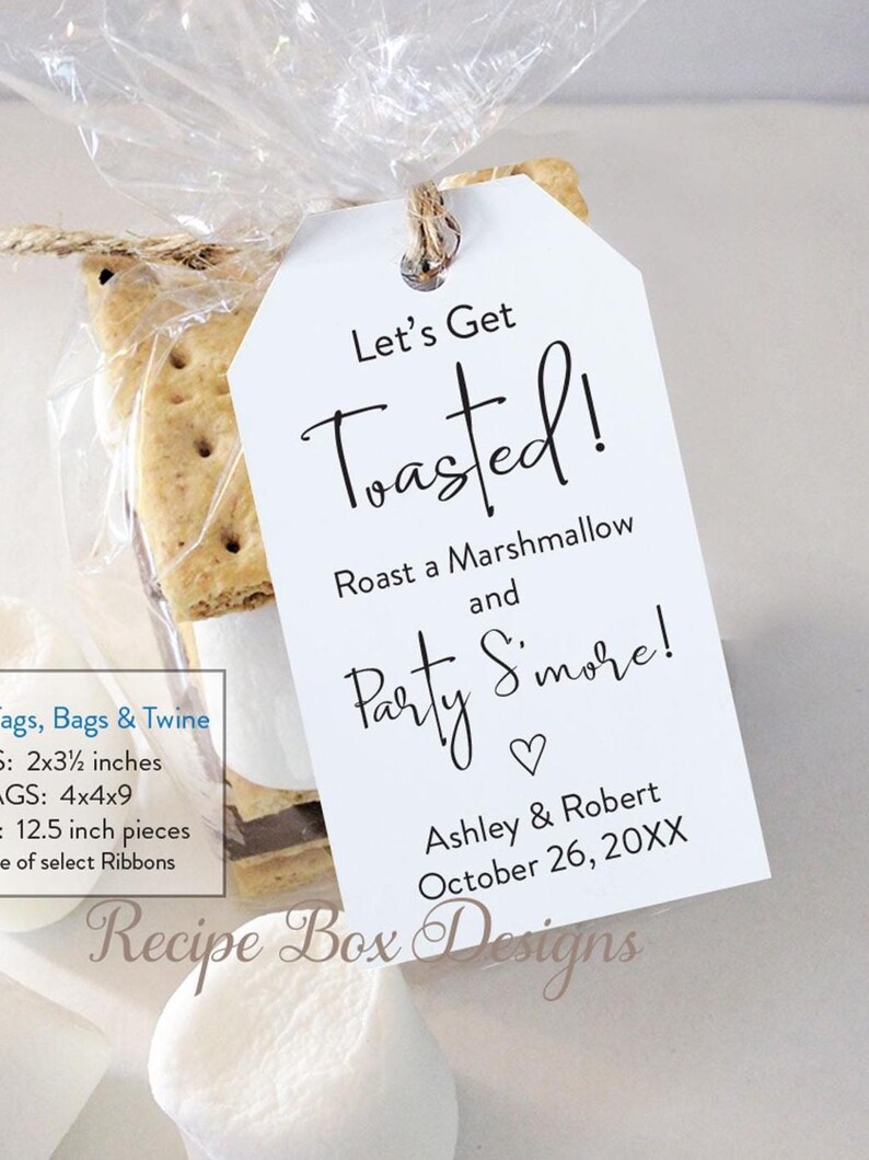 May include: A clear cellophane bag tied with twine, containing graham crackers and chocolate, with a white tag that reads "Let's Get Toasted!" and "Party S'more!" with a heart. The tag also includes a date and names.