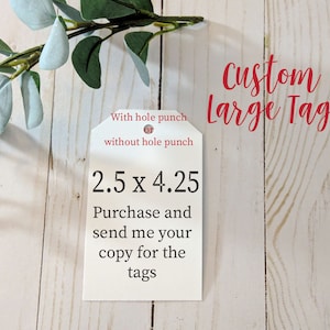 May include: White tag with the text "Custom Large Tag" in red. The tag is 2.5 inches by 4.25 inches. The text "With hole punch or without hole punch" is also on the tag. The tag is on a wooden surface.