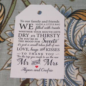 May include: White favor tag with black text that reads "To our family and friends, we made a little bag filled with treats, whether your mouth gets dry or thirsty or you're in the mood for sweets, it's just a small token full of our love, hugs and kisses, to thank you for the trip you made to see the new Mr and Mrs Alyson and Onofrio."