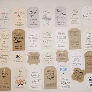 May include: A collection of various gift tags with printed text and designs. The tags are in different shapes and sizes, with messages like "Thank You," "Baby Shower," and "Happy Birthday." The color palette includes white, beige, and brown.