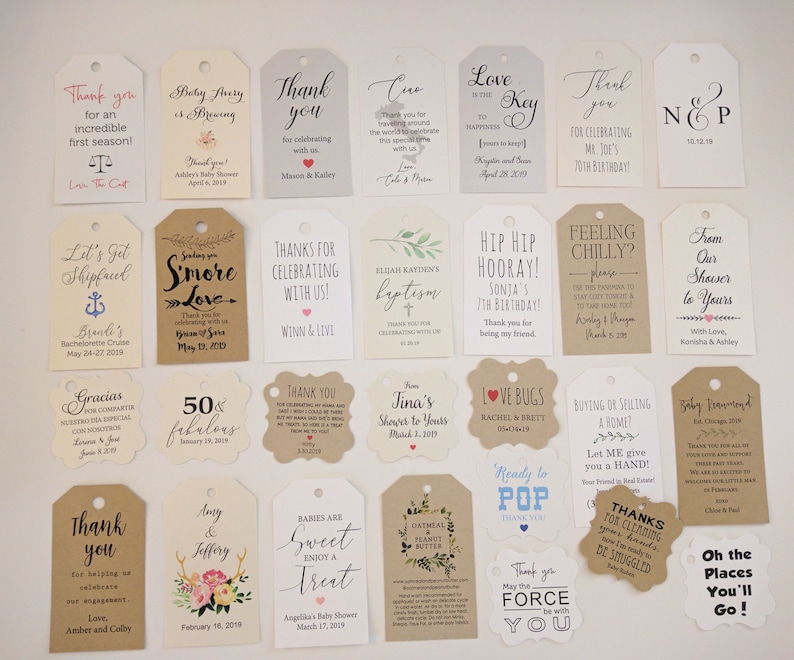 May include: A collection of various gift tags with printed text and designs. The tags are in different shapes and sizes, with messages like "Thank You," "Baby Shower," and "Happy Birthday." The color palette includes white, beige, and brown.