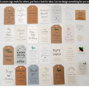 May include: A collection of custom gift tags in various shapes and sizes, with handwritten calligraphy and decorative elements. The tags feature phrases like "Thank You," "Happy Birthday," and "Welcome," with dates and names.