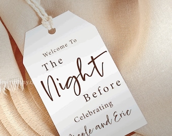 May include: White tag with brown text that reads "Welcome To The Night Before Celebrating Nicole and Eric". The tag is tied with twine and is on a wooden surface.