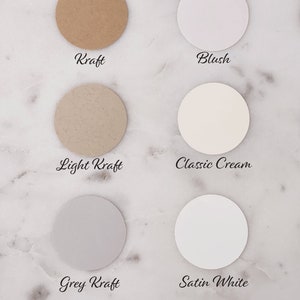 May include: Six circular paper samples in various neutral colors, including Kraft, Blush, Light Kraft, Classic Cream, Grey Kraft, and Satin White. Each sample has a label with its color name in a handwritten font.