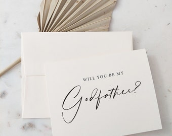 May include: A white card with black text that reads "Will you be my Godfather?"  The card is on a white surface with a dried palm leaf in the background. The text "RECIPE BOX DESIGNS.ETSY.COM" is at the bottom of the card.