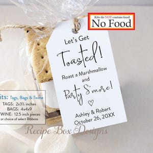 May include: A clear cellophane bag tied with twine, containing graham crackers and marshmallows, with a white tag that reads "Let's Get Toasted!" and includes a date. The tag is 2x3.5 inches. The kit does not contain food.