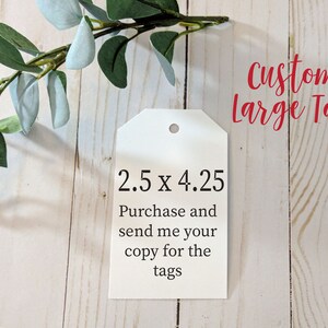 May include: White gift tag with the text "2.5 x 4.25" and "Purchase and send me your copy for the tags". The tag is on a white wood background. The text "Custom Large Tag" is written in red above the tag.