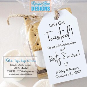 May include: A clear cellophane bag tied with twine, containing a s'mores treat. A white tag with the words "Let's Get Toasted!" is attached. The tag also includes the names Ashley & Robert and the date October 26, 20XX.