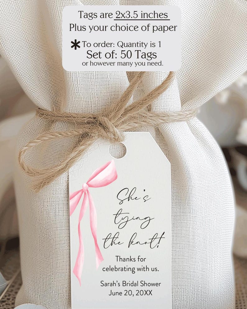 May include: A gift bag tied with twine, featuring a white tag with a pink bow illustration and the text "She's tying the knot!" The tag is 2 x 3.5 inches. The text also includes "Sarah's Bridal Shower" and the date.