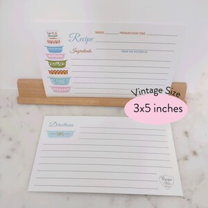 May include: A set of two vintage-style recipe cards with a blue and white floral design. The top card has a stack of colorful bowls and the text "Recipe" and "Ingredients". The bottom card has a single bowl and the text "Directions". The cards are 3x5 inches.