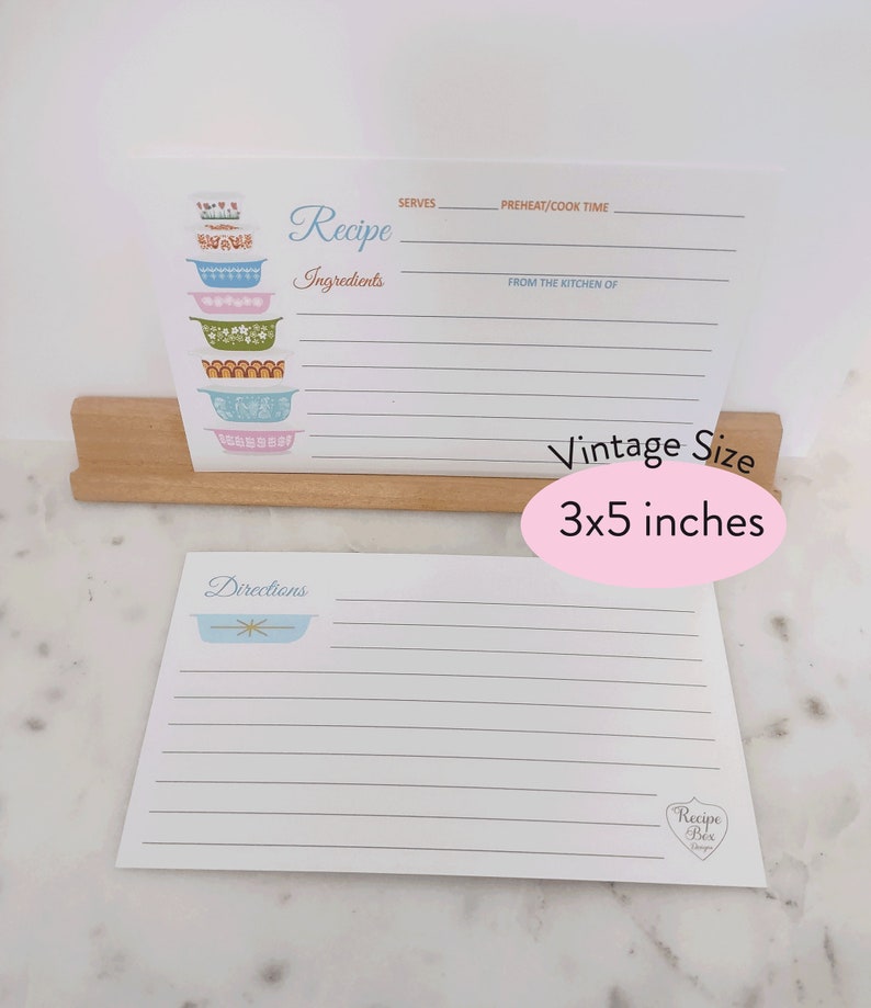 May include: A set of two vintage-style recipe cards with a blue and white floral design. The top card has a stack of colorful bowls and the text "Recipe" and "Ingredients". The bottom card has a single bowl and the text "Directions". The cards are 3x5 inches.