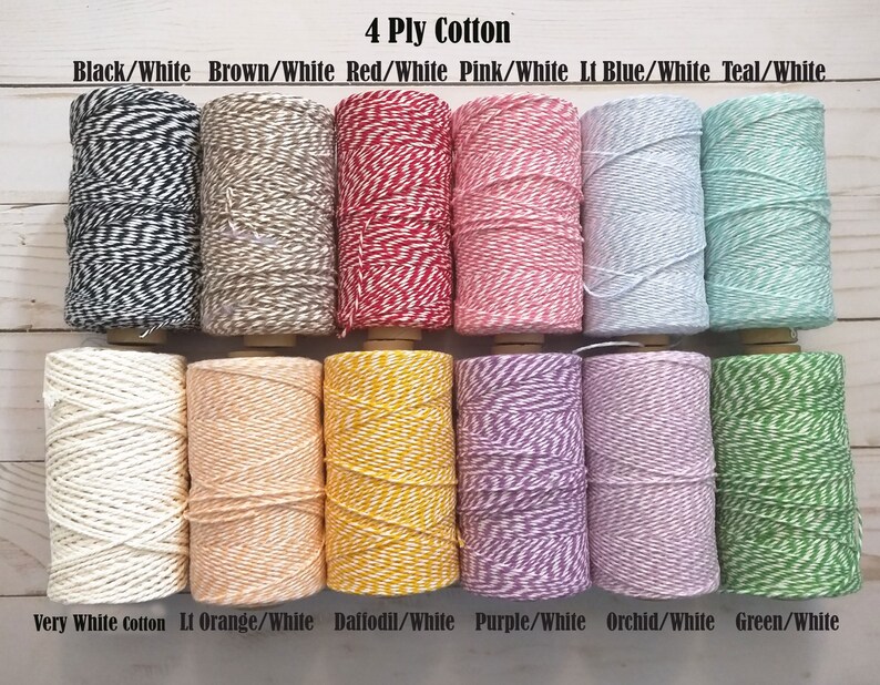 May include: A collection of twelve spools of 4-ply cotton twine in various colors. The color combinations include black/white, brown/white, red/white, pink/white, light blue/white, and teal/white. Additional colors are very white, light orange/white, daffodil/white, purple/white, orchid/white, and green/white.