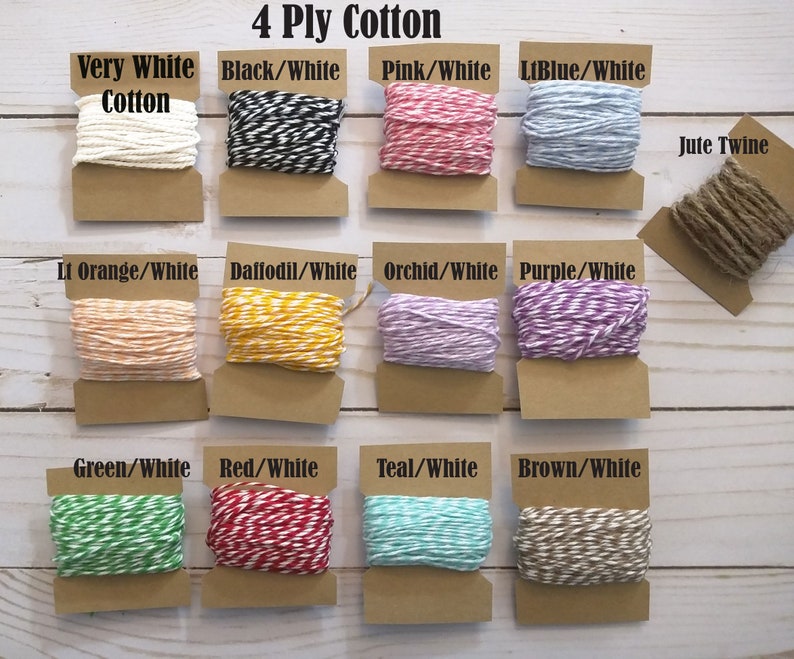 May include: A selection of 4-ply cotton twine in various colors, including white, black/white, pink/white, and light blue/white. Also includes jute twine. Each spool is displayed on a brown card. Text on the image reads "4 Ply Cotton".
