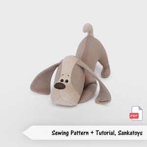 Pode incluir: Um brinquedo de pelúcia em forma de cão, com corpo castanho claro, rosto e orelhas bege e nariz castanho escuro. O texto "Sewing Pattern + Tutorial, Sankatoys" é exibido abaixo.