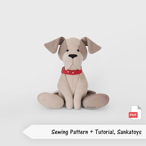 May include: A soft toy dog in beige and brown, wearing a red collar. The dog is seated with its legs outstretched. The text "Sewing Pattern + Tutorial, Sankatoys" is below the dog.