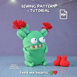 Puede incluir: Un monstruo cactus de peluche verde con ojos blancos, boca sonriente y detalles de pompón rojo. El texto "SEWING PATTERN + TUTORIAL" y "Feed me hearts" son visibles. La imagen también incluye un icono PDF y dos peluches en forma de corazón rojo. Parte de la colección Plant Monster.