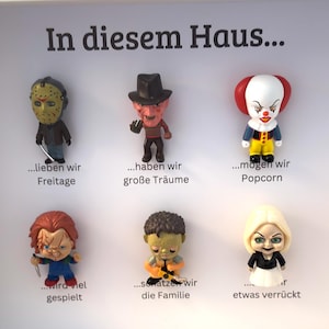 Könnte beinhalten: Ein weißes Schild mit dem deutschen Text "In diesem Haus..." und sechs Horrorfilm-Charakterfiguren. Die Figuren umfassen Jason, Freddy Krueger, Pennywise, Chucky und andere. Jede Figur hat einen Satz darunter.
