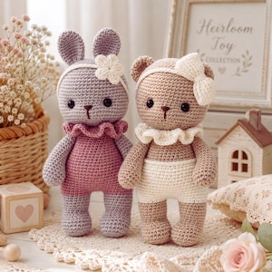 Peut inclure: Deux animaux en peluche crochetés, un lapin lavande et un ours beige. Le lapin porte une barboteuse rose, un col à volants et un bandeau à fleurs blanches. L'ours porte un short blanc, un col à volants et un bandeau à nœud blanc. Yeux noirs.
