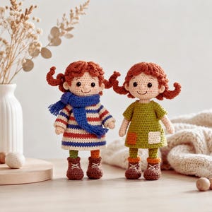 May include: Two handmade crochet dolls with reddish-brown yarn hair styled in pigtails. The left doll wears a blue scarf and a red, white, and blue striped dress with brown boots. The right doll wears a green dress with patches and brown boots.