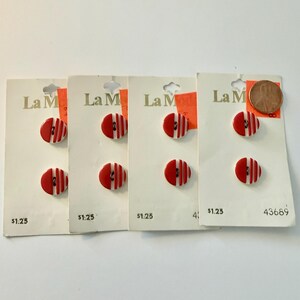 May include: Four cards of La Mode brand buttons. Each card has two red and white striped buttons. The buttons are oval-shaped with a flat back. A penny is included for size reference. The cards have the price $1.25.