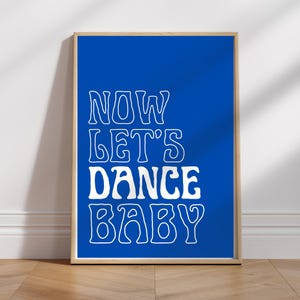Può includere: Un poster blu con testo bianco che recita "NOW LET'S DANCE BABY" in un font retrò.