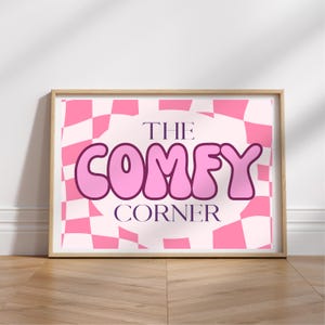 May include: A pink and white checkered background with the text "THE COMFY CORNER" in a pink bubble font.