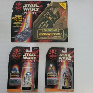 May include: A collection of Star Wars Episode I CommTech reader toys and action figures, still in their original packaging. The packaging features images of characters and the text "NOW FIGURES TALK!" and "ELECTRONIC COMMTECH READER".