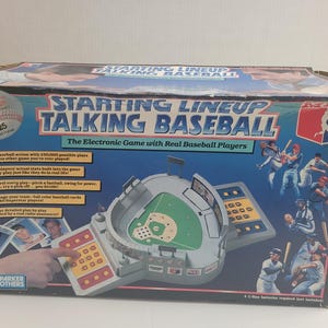 May include: A vintage "Starting Lineup Talking Baseball" electronic game box. The box features a baseball stadium design with a green field and a keypad. Text includes "The Electronic Game with Real Baseball Players" and "Hall of Fame Cartridge".