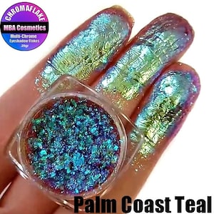 May include: A small jar of teal, green, and blue iridescent eyeshadow flakes. The jar is labeled "MBA Cosmetics Multi-Chrome Eyeshadow Flakes 20gr". The text "Palm Coast Teal" is written below the jar.