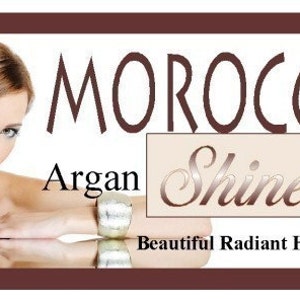 May include: Image of a woman with long, brown hair, promoting Moroccan Argan Shine Serum. The product name is displayed in elegant script, with the words "Beautiful Radiant Hair" below. The image is framed in a dark brown border.