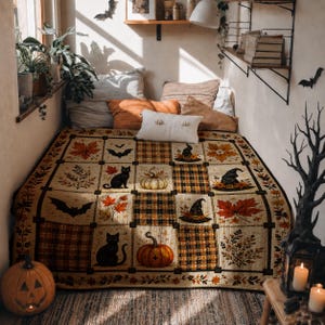 May include: A rectangular quilt featuring a patchwork design with alternating squares of plaid patterns and seasonal motifs including black cats, orange pumpkins, witch hats, bats, and autumn leaves in shades of orange, brown, and cream.