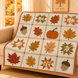 Könnte beinhalten: Eine Steppdecke mit einem Gittermuster aus abwechselnden Quadraten, die herbstliche Motive wie verschiedene Ahorn- und Eichenblätter, orangefarbene Kürbisse, braune Eicheln und geometrische Sternmuster in Orange, Gelb, Braun und Grün zeigen.