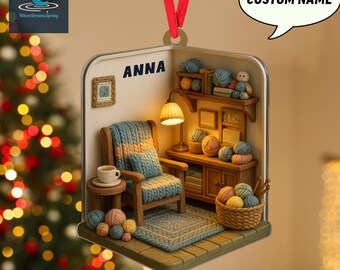May include: A 2D flat Christmas ornament featuring a cozy miniature room with a chair, rug, and yarn. The ornament has a red ribbon for hanging and includes the text "ANNA" and "CUSTOM NAME".
