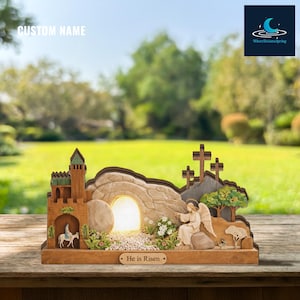 May include: A wooden Easter scene with a glowing tomb, angel, and crosses. The scene includes a castle, a figure on a donkey, and the text "He is Risen". The background is a blurred outdoor scene.