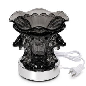 May include: A dark gray, translucent glass wax warmer featuring a scalloped top edge and molded dolphin figures around the central column. The glass vessel sits on a circular, reflective silver base and includes a white electrical cord and plug.