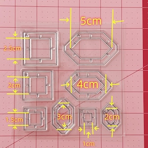 Puede incluir: Una lámina de plástico transparente con seis plantillas de diferentes tamaños para manualidades. Las plantillas están etiquetadas con A, B, C y D. La plantilla más grande mide 5 cm de ancho y 2,5 cm de alto. La plantilla más pequeña mide 1 cm de ancho y 2 cm de alto.