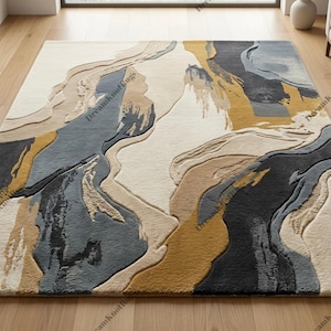 Könnte beinhalten: Ein rechteckiger Teppich mit einem abstrakten Design aus fließenden, geschichteten Formen in den Farben Creme, Anthrazit, Schieferblau und Senfgelb. Die Oberfläche hat eine strukturierte, geschnitzte Optik mit variierenden Florhöhen.