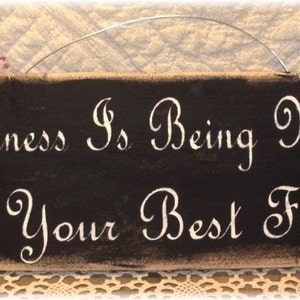 May include: A black wooden sign with white painted text that reads "Happiness is being married to your best friend".