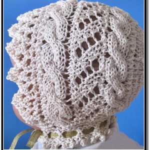 May include: A crocheted baby bonnet in a cream color with a delicate lace pattern. The bonnet has a scalloped edge and is made with a fine yarn.
