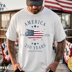 May include: White t-shirt with a patriotic design. The shirt features the word "AMERICA" above a map of the United States with the American flag incorporated. The text "1776" and "2026" flank the map, with "250 YEARS" below.