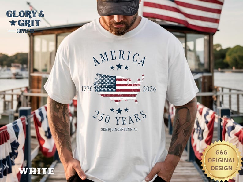 May include: White t-shirt with a patriotic design. The shirt features the word "AMERICA" above a map of the United States with the American flag incorporated. The text "1776" and "2026" flank the map, with "250 YEARS" below.