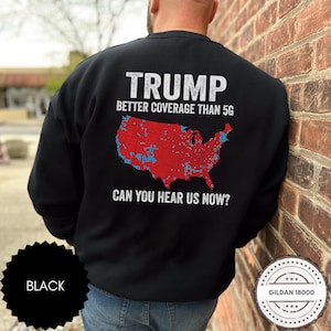 May include: Black sweatshirt with a white graphic of a map of the United States with red and blue markings. The text "TRUMP BETTER COVERAGE THAN 5G CAN YOU HEAR US NOW?" is printed on the sweatshirt.