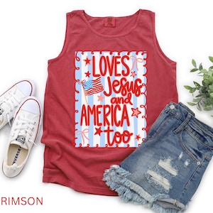 K&ouml;nnte beinhalten: Karmesinrotes Tanktop mit dem Text "Loves Jesus and America too" in Rot und Wei&szlig;. Das Tanktop wird mit Jeansshorts und wei&szlig;en Turnschuhen kombiniert. Das Design beinhaltet eine amerikanische Flagge und Sterne.